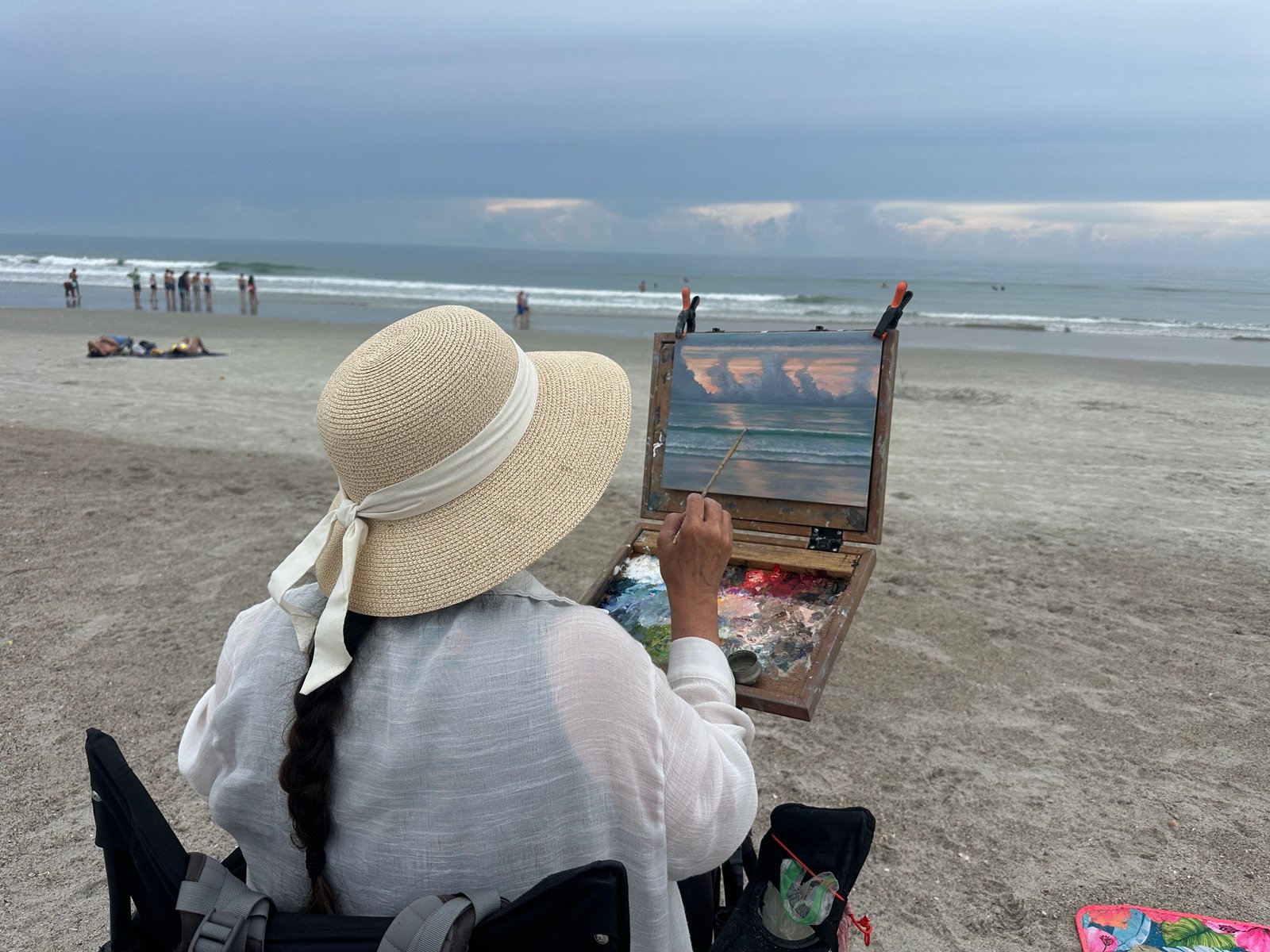 Heather Collins painting a sunset seascape at the beach